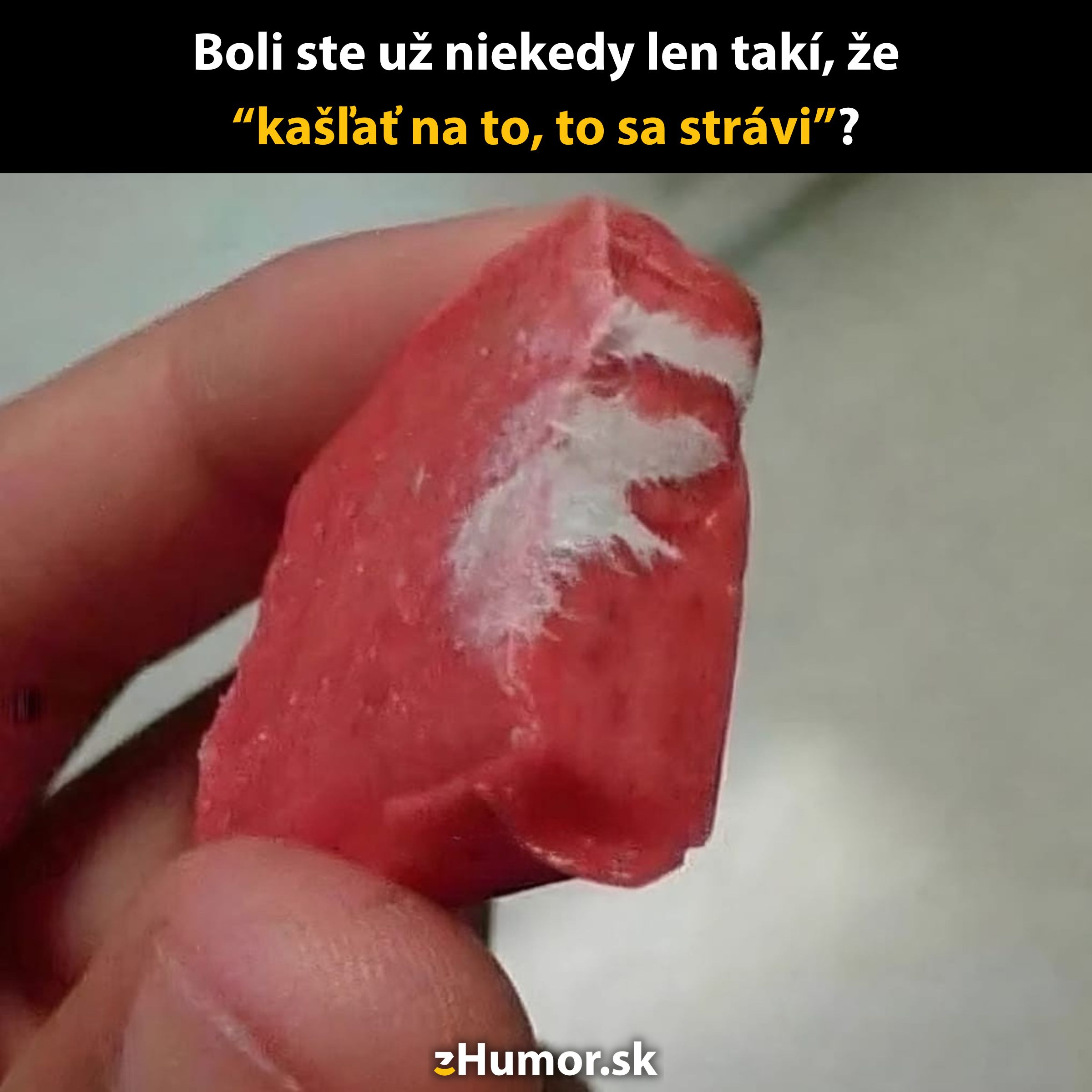 Červené kriedové mydlo držané v ruke s vtipným textom o strávení.