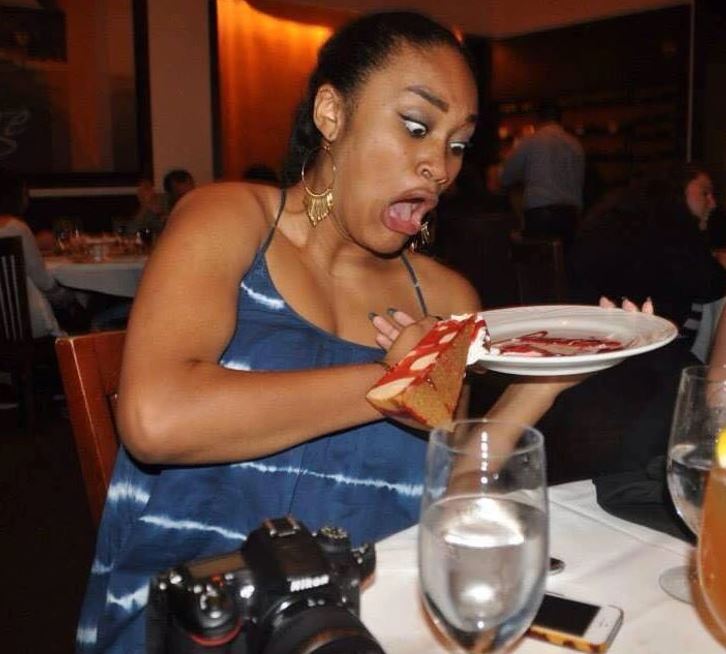 Osoba v reštaurácii prekvapene reaguje na koláč na tanieri, ktorý sa zrútil nabok.