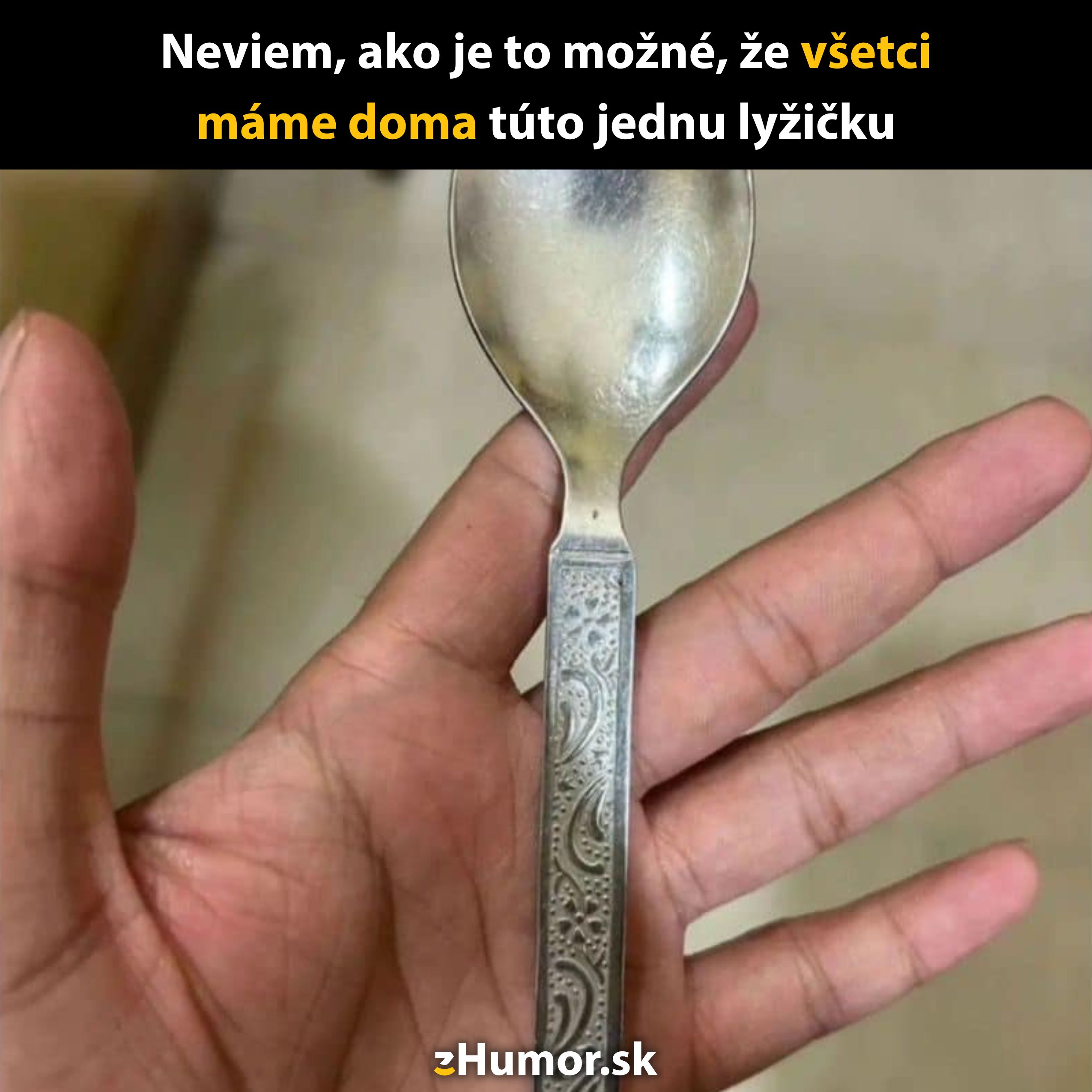 Ruka držiaca striebornú lyžičku s dekoratívnym vzorom, známu z mnohých domácností.