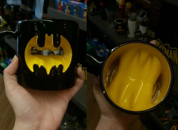 Čierny hrnček so žltým symbolom netopiera, ideálny pre fanúšikov komiksov.