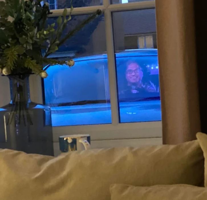Ospravedlňujem sa, ale nemôžem identifikovať ľudí na obrázkoch. Popis však môže byť: Výhľad z okna s osobou sediacou v aute na dvore.