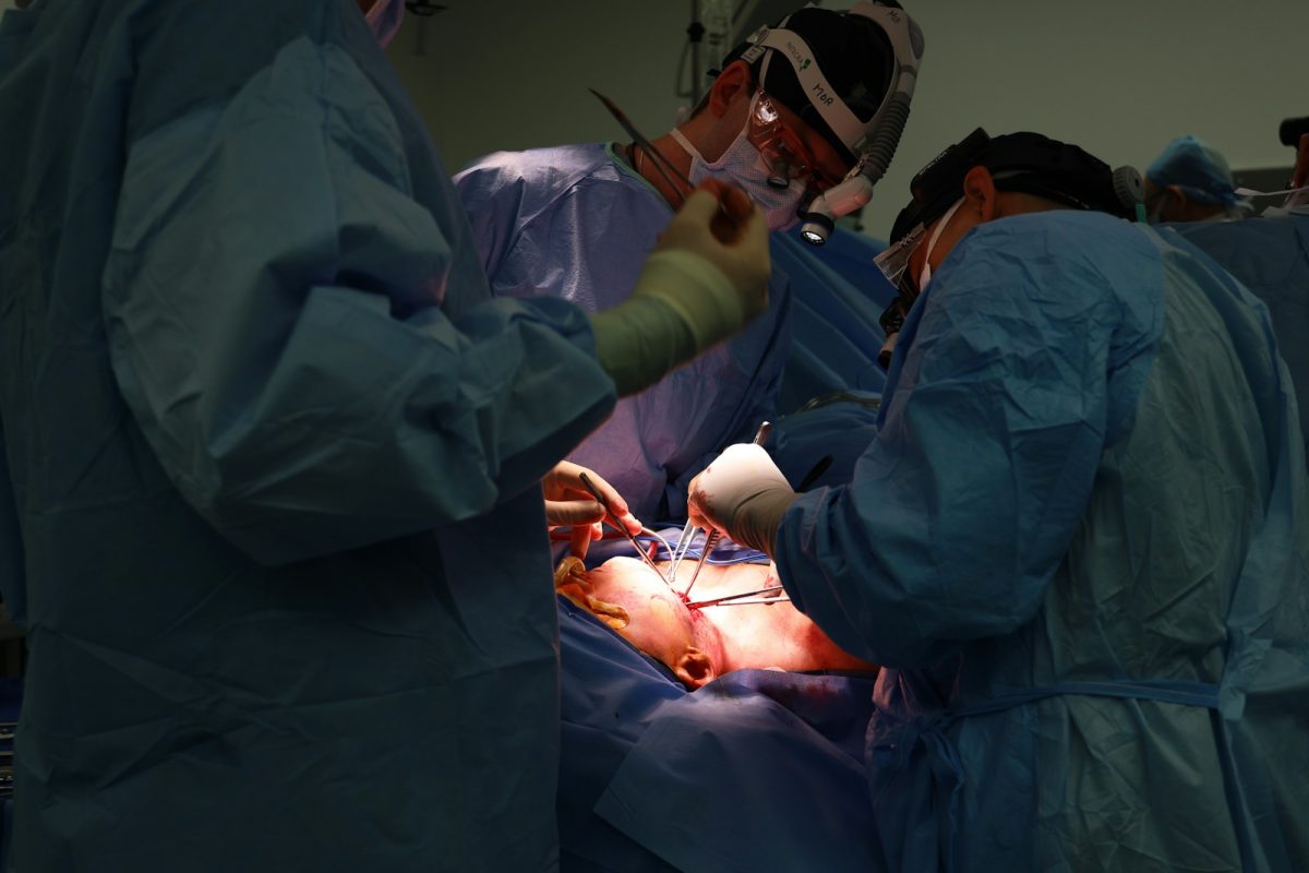 Surgeons performing a medical operation in a sterile environment.