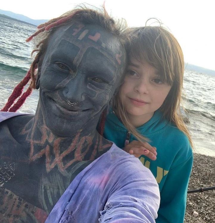 Ospravedlňujem sa, neviem identifikovať osoby, ale obrázok zobrazuje dvoch ľudí pri mori s výrazným tetovaním na tvári jedného z nich.