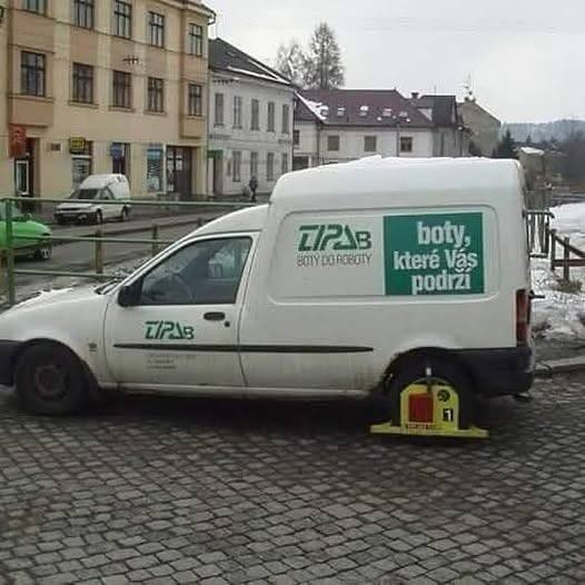 Dodávka s vývesným štítom boty, které vás podrží so zablokovaným kolesom na ulici.