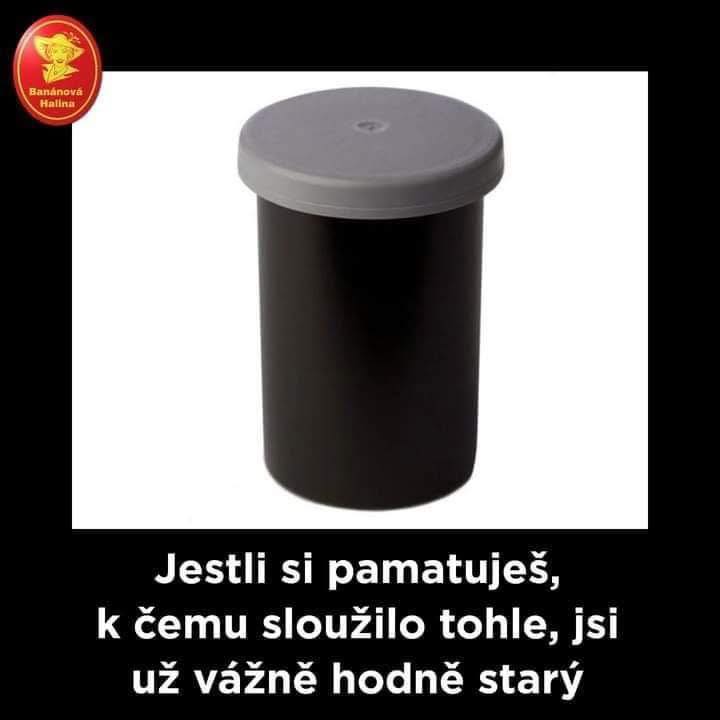 Čierny plastový obal na filmy s šedým vrchnákom, používaný v analógovej fotografii.