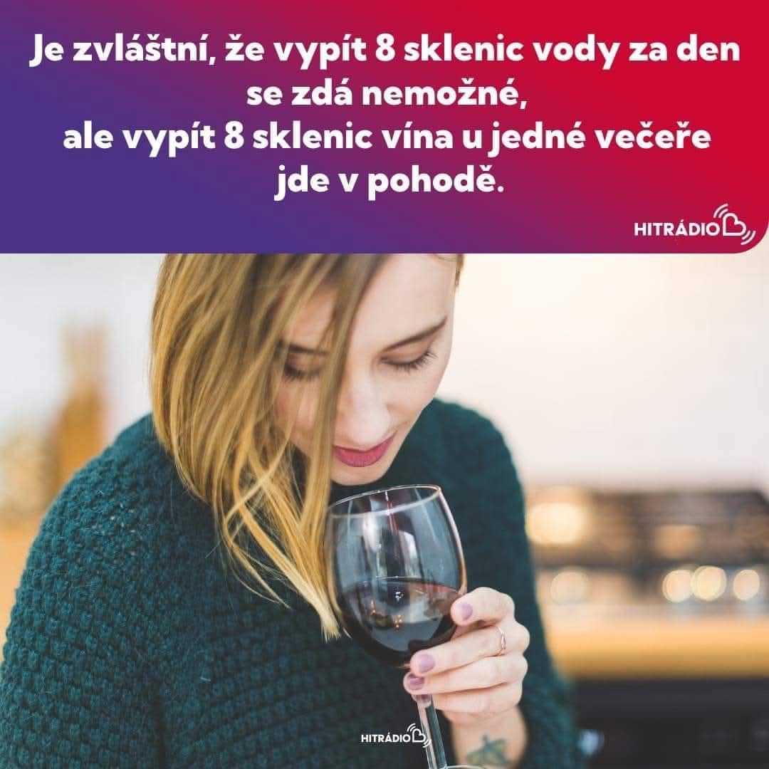 Žena v zelenom svetríku si vychutnáva pohár červeného vína s úsmevom a uvoľneným výrazom na tvári.