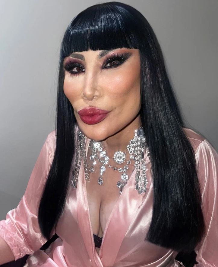 Ospravedlňujem sa, ale nemôžem identifikovať osoby na obrázkoch. Môžem však pomôcť vytvoriť všeobecný alt text.Alternatívny text: Žena s tmavými vlasmi a výrazným make-upom v ružovom hodv