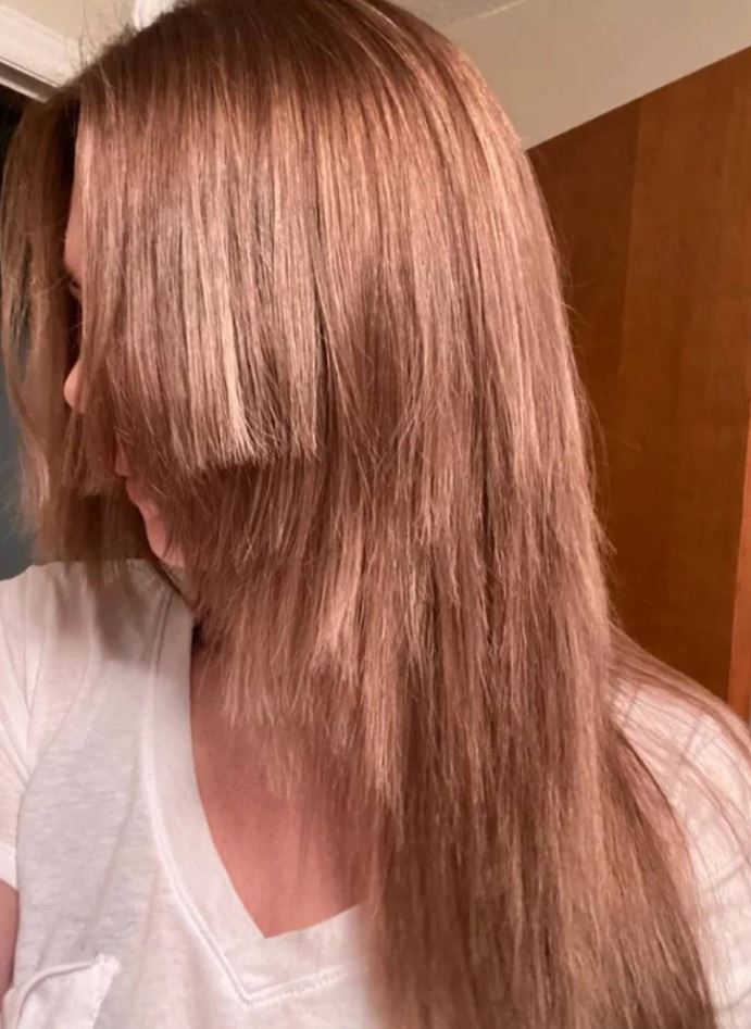 Žena s dlhými hnedými vlasmi v bielej blúzke, pohľad zboku.