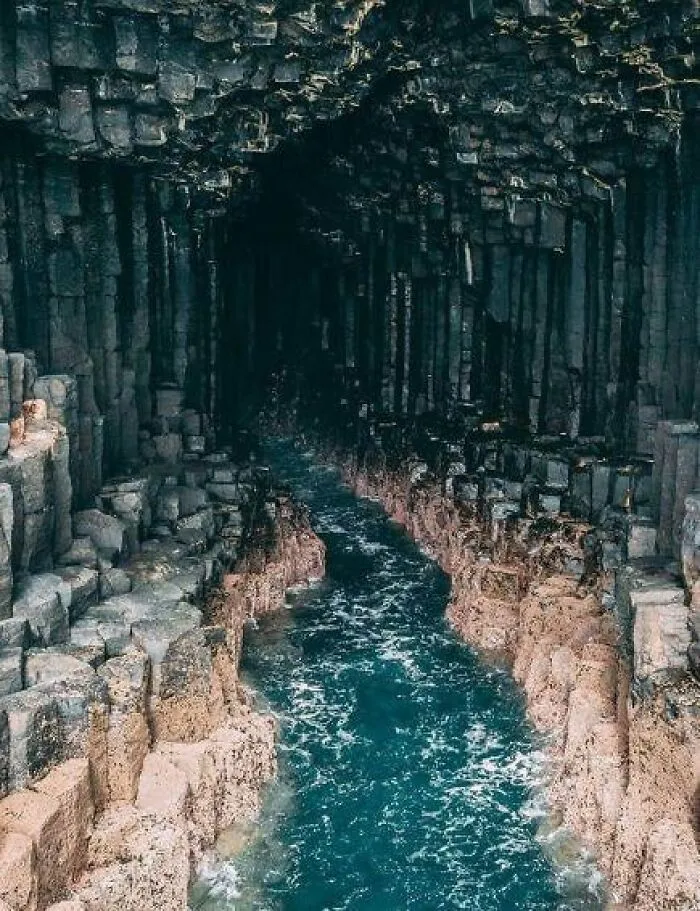 Magická bazaltová jaskyňa s tyrkysovou vodou a impozantnými stĺpmi vytvorenými prírodnými silami.