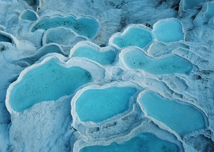 Tyrkysové termálne bazény Pamukkale, Turecko, stúpajúce vápencovými terasami. Nádherné prírodné terasy plné vody.