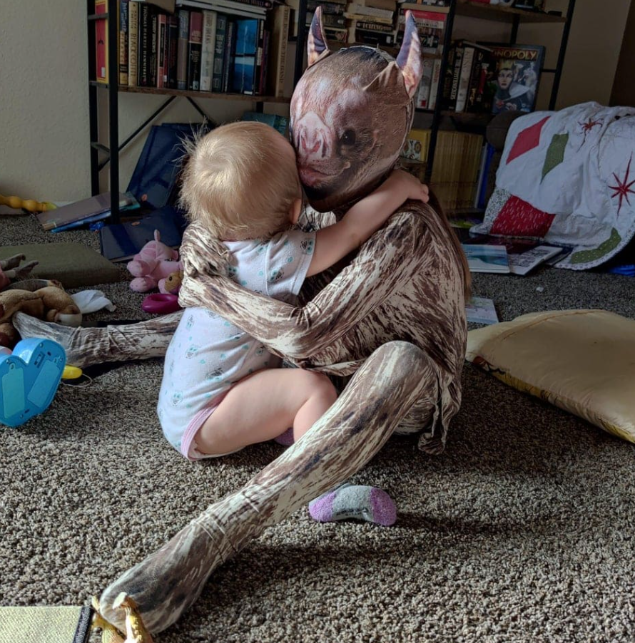 Dieťa objíma osobu v kostýme netopiera v detskej izbe.