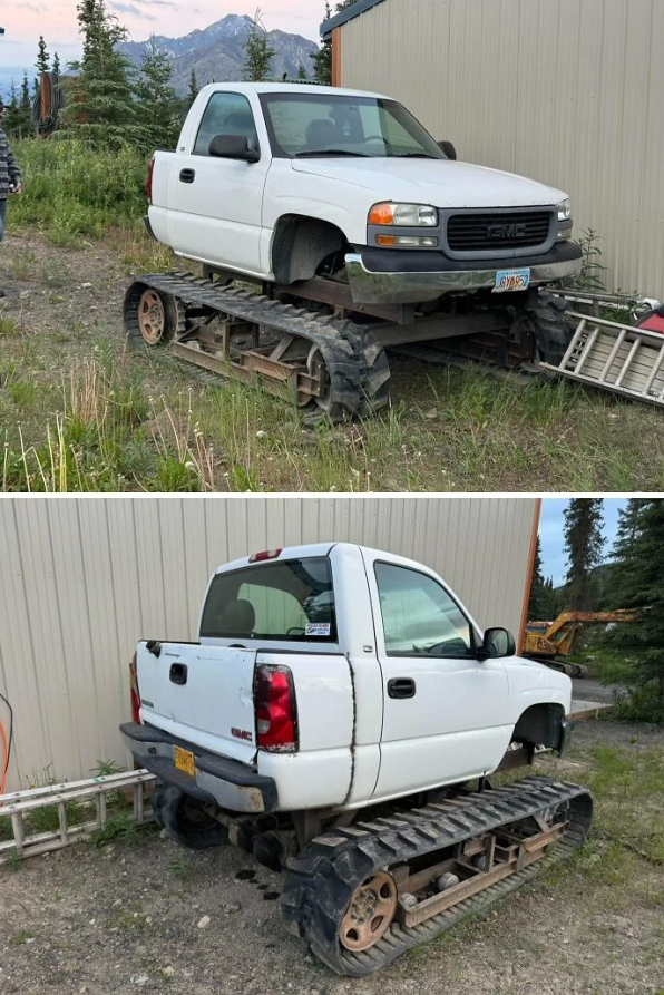 Biele auto s pásmi namiesto kolies stojí vedľa budovy, obklopené zeleňou a horami.