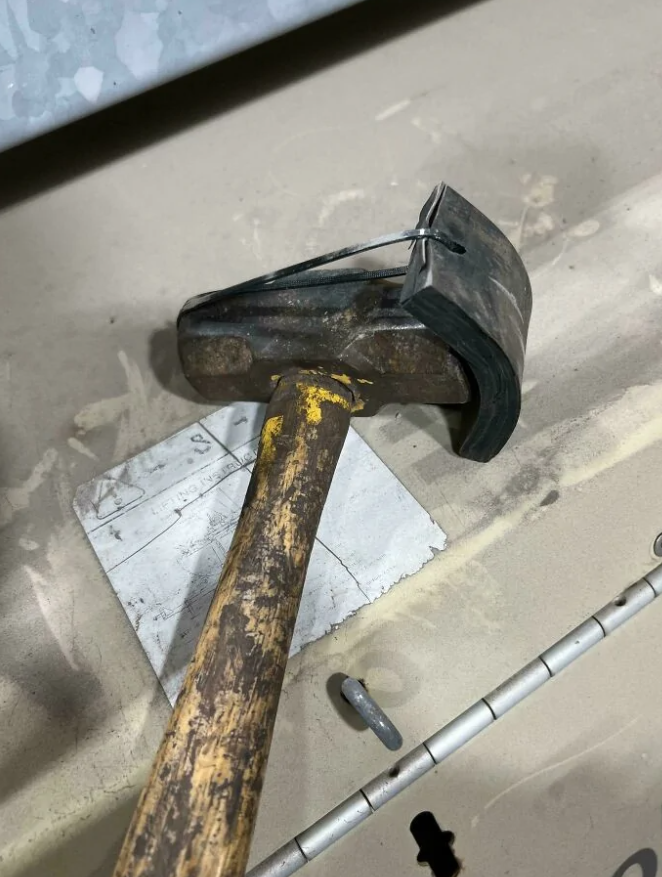 Kladivo s pripevnenou gumenou podložkou na ochranu povrchu počas práce.