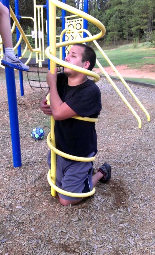 Muž zachytený v špirálovom hernom prvku na detskom ihrisku.