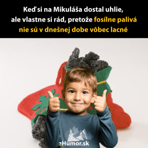 Chlapec s palcami hore pred vianočnou ponožkou plnou uhlia, vtipný pohľad na fosílne palivá.