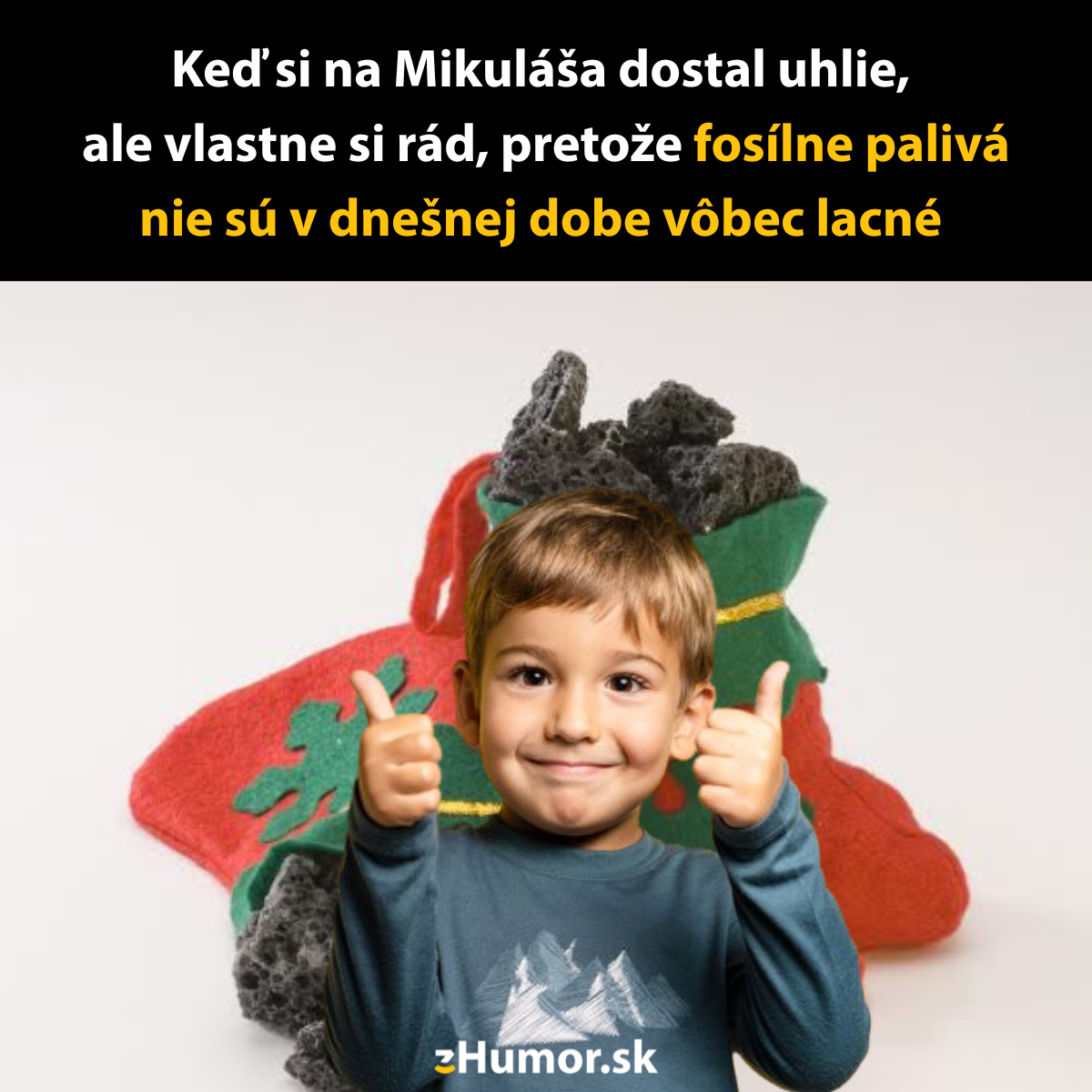 Chlapec s palcami hore pred vianočnou ponožkou plnou uhlia, vtipný pohľad na fosílne palivá.