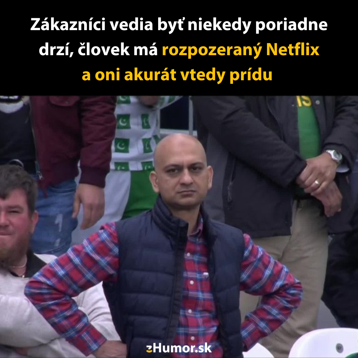 Muž s nespokojným výrazom počas sledovania zápasu v spoločnosti ďalších divákov.