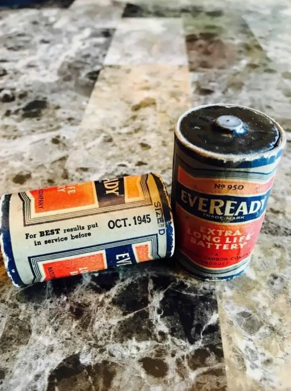 Dve staré batérie Eveready na mramorovom povrchu, z jednou s dátumom OCT. 1945.