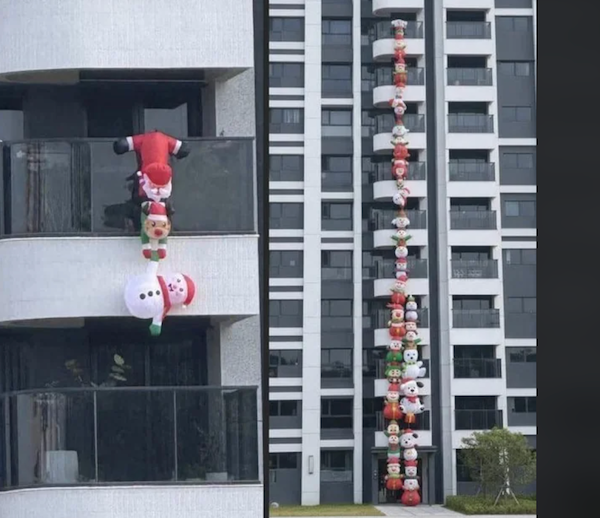 Séria vianočných nafukovacích postavičiek lezie po balkónoch výškovej budovy, tvorba sviatočnej dekorácie.