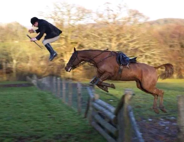 Jazdec preskakuje plot vedľa koňa v pohybe počas tréningu na vonkajšej lúke.