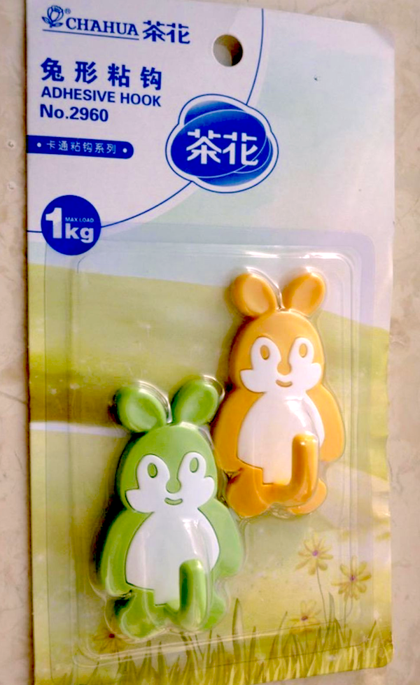 Detské adhesívne háčiky v tvare králika, nosnosť 1 kg, oranžová a zelená farba. Praktický dizajn na zavesenie.