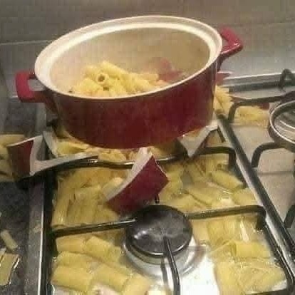 Rozbitý hrniec s cestovinami na sporáku, vylial sa obsah, tvorí neporiadok okolo horáka.