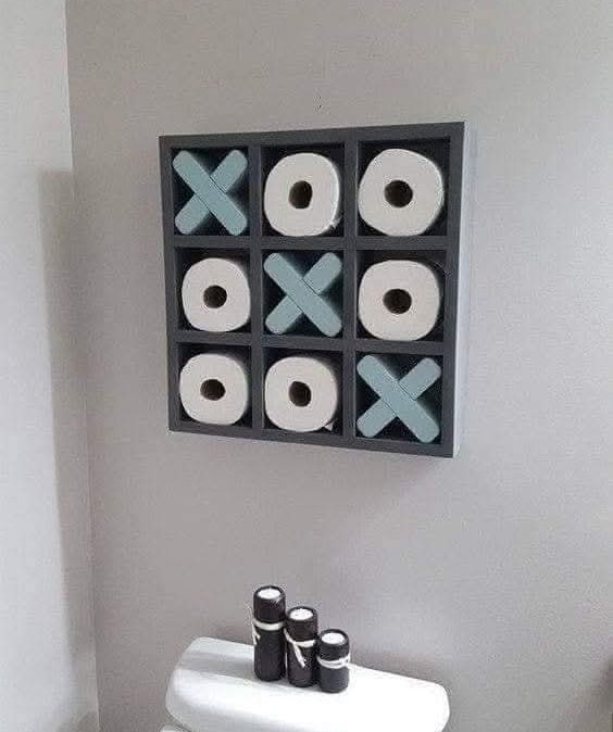 Tic-tac-toe dekorácia s toaletným papierom na stene v modernom kúpeľňovom interiéri.