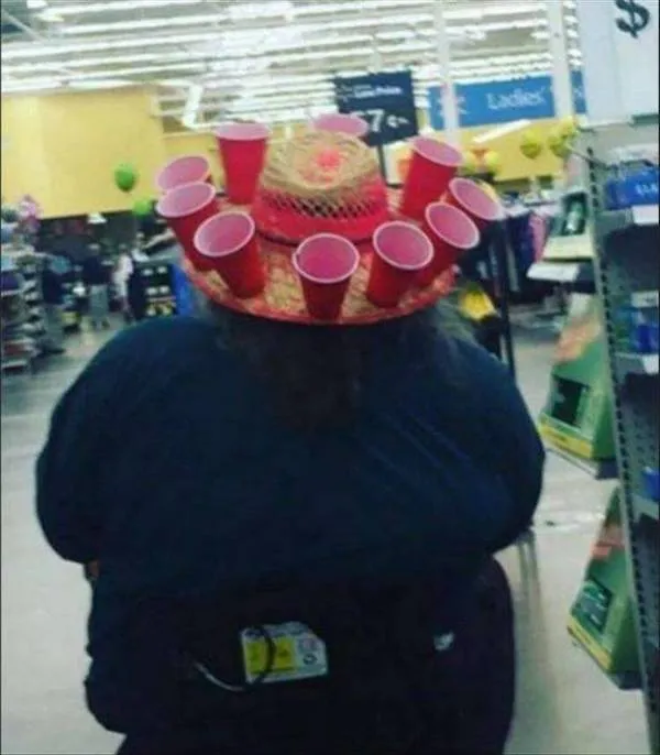Osoba s klobúkom ozdobeným červenými pohármi nakupuje v supermarkete.