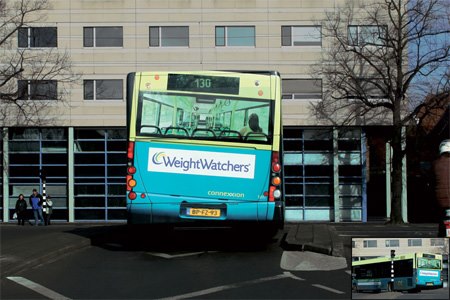 Autobus s reklamou na WeightWatchers odchádza z zastávky v meste, v pozadí moderná budova a stromy.