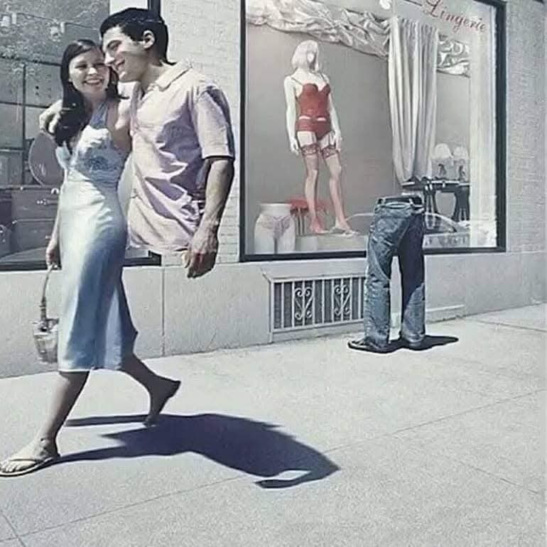 Pár prechádzajúci okolo výkladu s oblečením, kde sú nohavice, no už bez ich majiteľa.