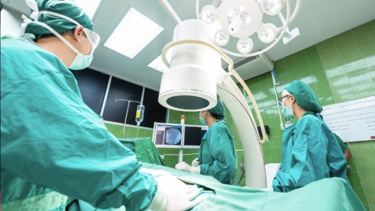 Lekársky tím v operačnej sále počas chirurgického zákroku s modernými prístrojmi a monitorovaním.