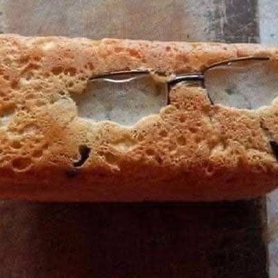 Špongia s okuliarmi, vytvára dojem ľudskej tváre na drevenom povrchu.