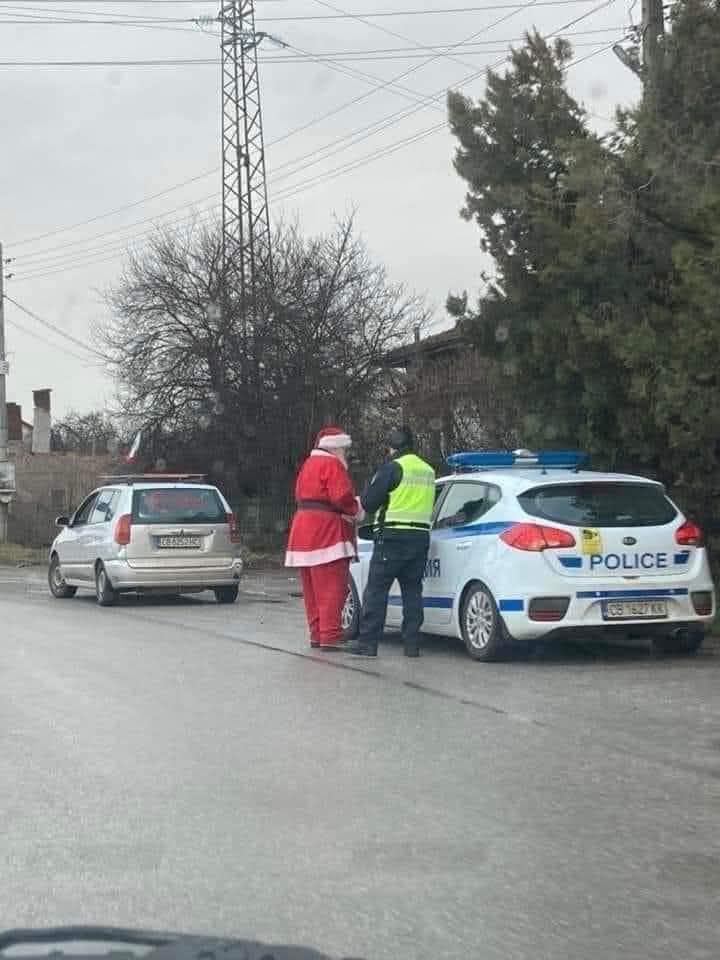 Santa Claus zastavený políciou na cestnej kontrole v zasneženom meste.