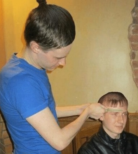 Osoba strihá vlasy druhému človeku v interiéri, používa hrebeň a nožnice, neformálna atmosféra.