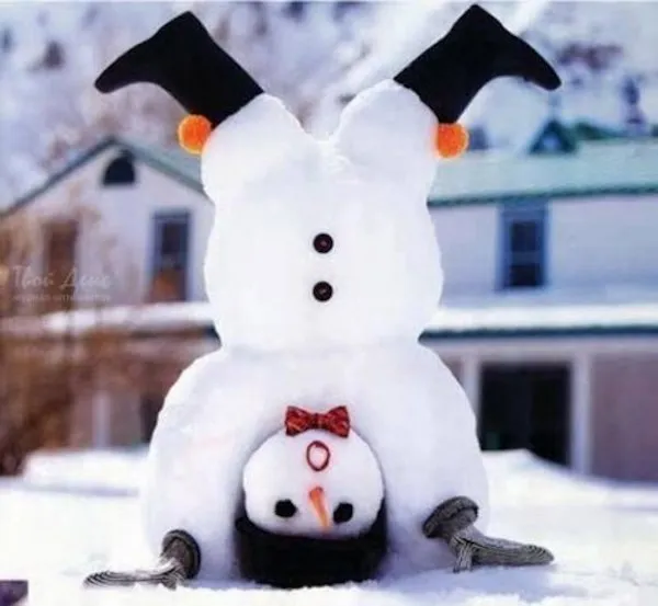 Snehuliak stojí na hlave so smejúcou sa tvárou, červeným motýlikom a snehovou krajinou v pozadí.