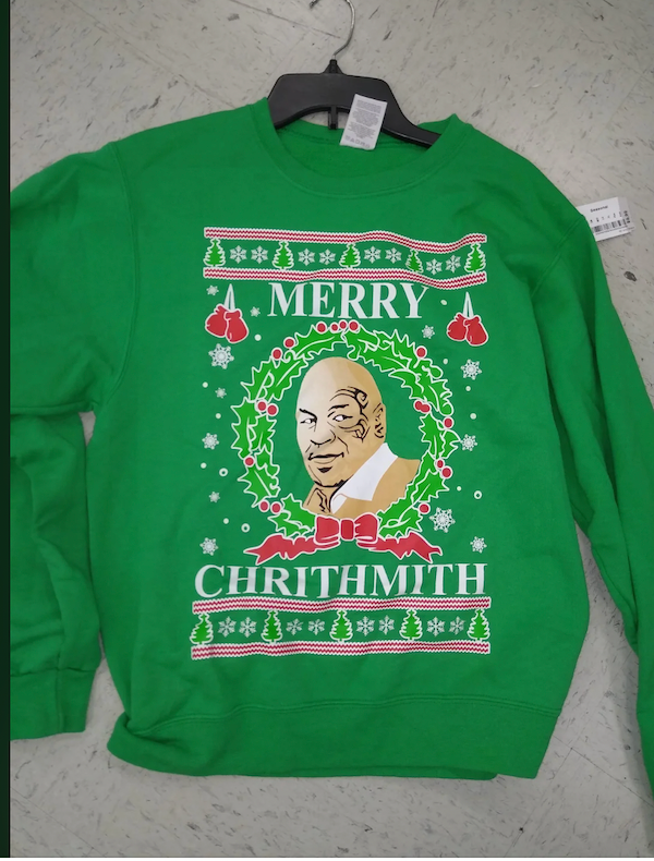 Zelený vianočný sveter s motívom vianočného venca a humorným textom Merry Chrithmith.