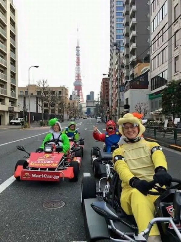 Go-kart jazda v kostýmoch cez mesto s vežou na pozadí.