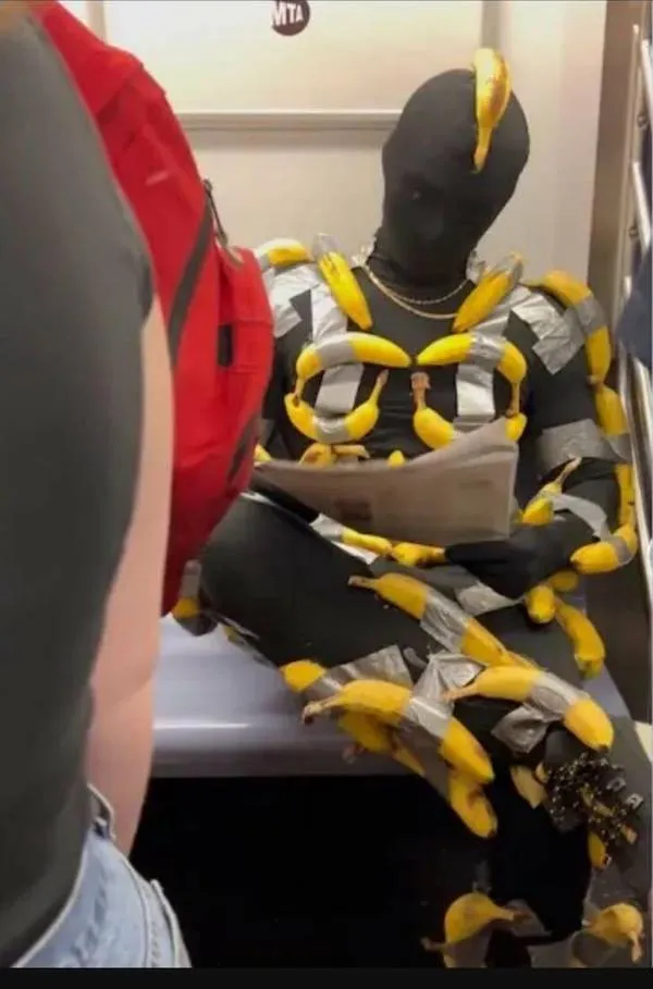 Muž vo vlaku v originálnom kostýme z banánov a pásky, čítajúci noviny.