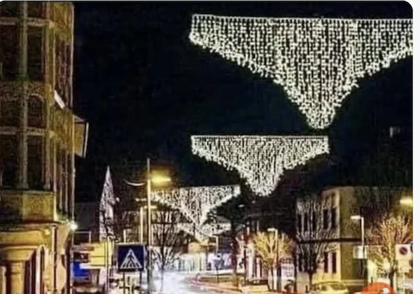 Vianočné svetelné dekorácie v tvare spodnej bielizne visia nad ulicou v nočnom meste.