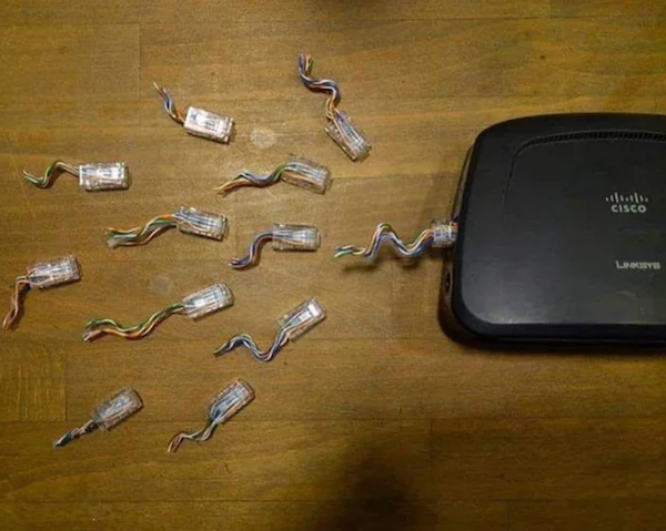 Router s viacerými odpojenými ethernetovými konektormi na drevenom povrchu.