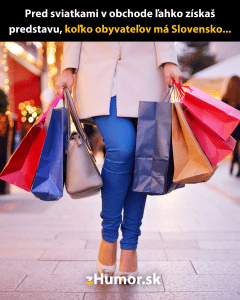 Žena nesúca niekoľko nákupných tašiek na rušnej ulici v predvianočnom období.