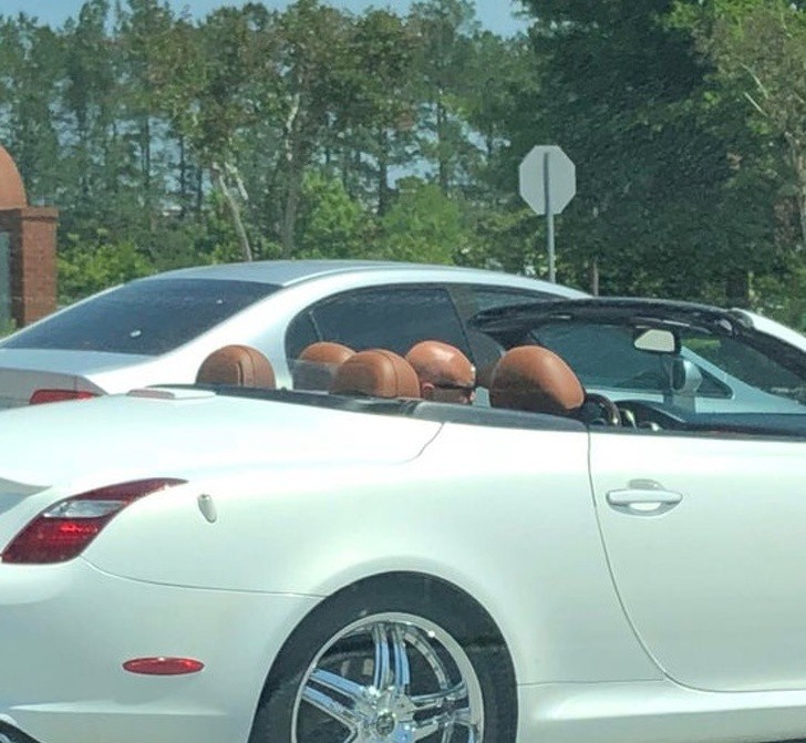 Biele kabriolet auto s dvoma svetlohnedými sedačkami na slnečnej ceste.