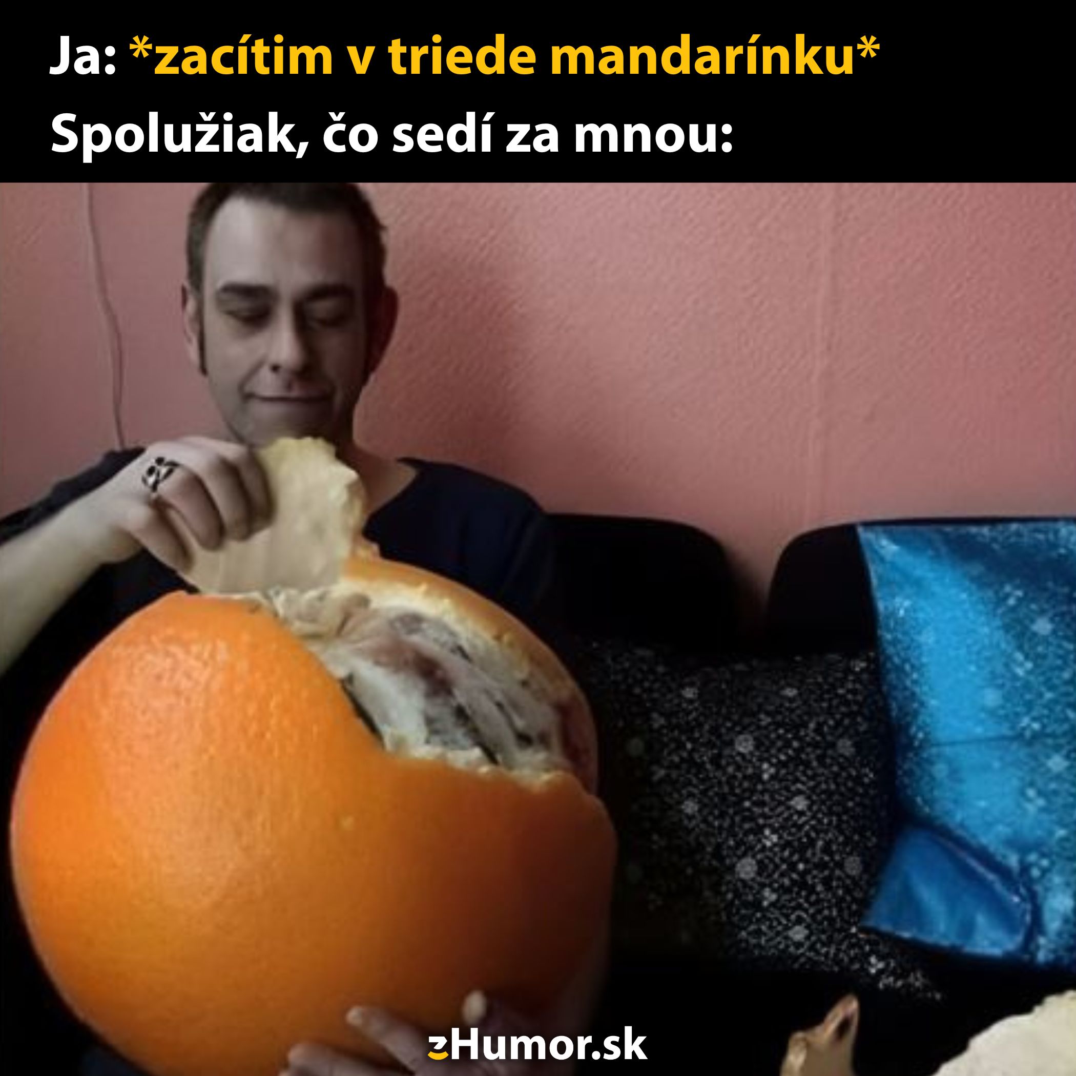Muž šúpe obrovskú mandarínku, zatiaľ čo sa za ním smeje jeho spolužiak, vtipná situácia v škole.