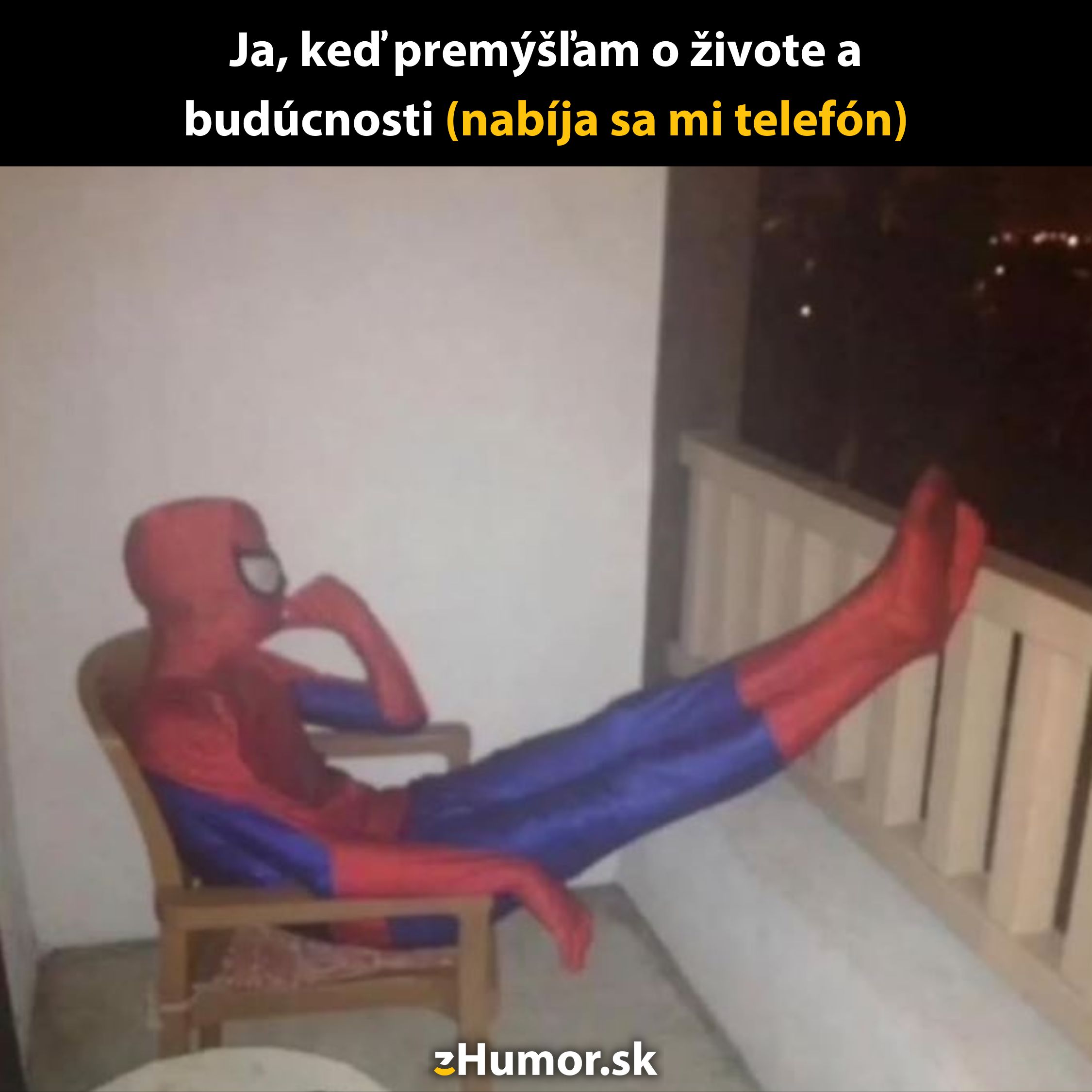 Osoba v kostýme Spider-Mana sedí na balkóne so zdvihnutými nohami, premýšľa o živote počas nabíjania telefónu.