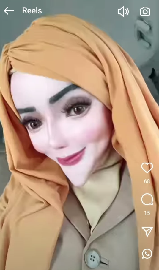 Žena v oranžovom šatke a hnedosti pre selfie so zdôrazneným make-upom, usmievajúca sa na kameru.