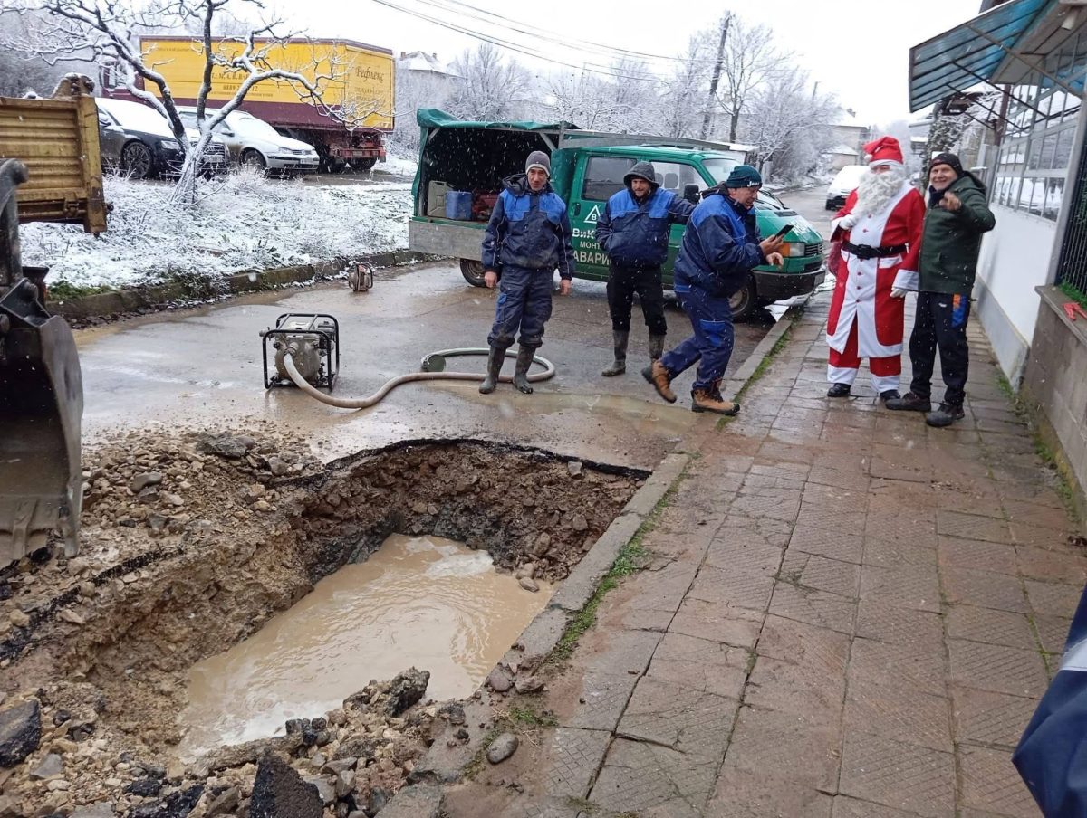 Vianočný kostým na stavbe: Vianočná nálada pri oprave cesty po zime s prítomnosťou rozľahlej jamy.