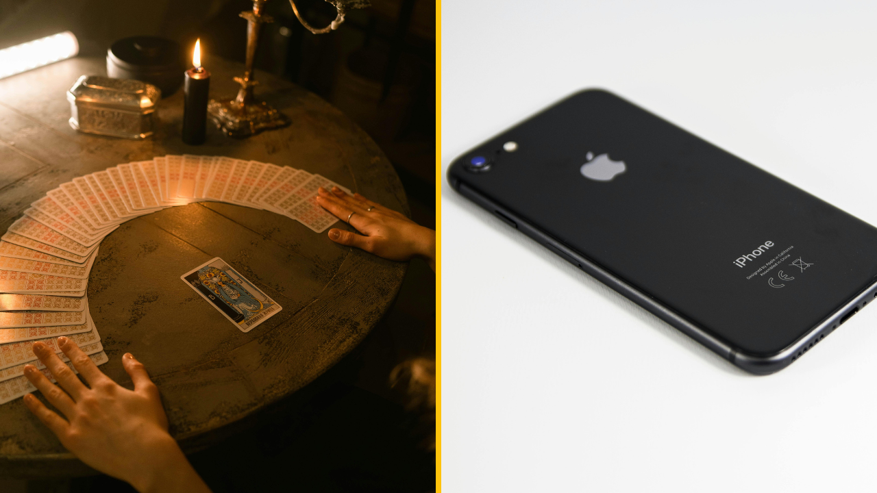 Tarotové karty na stole pri sviečke a čierny iPhone na bielej ploche.