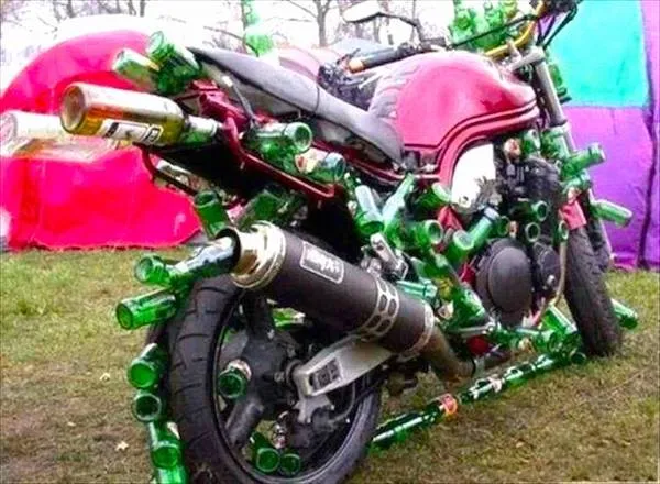 Motorka pokrytá pivovými fľašami na festivale; kreatívny umelecký dizajn z recyklovaných materiálov.
