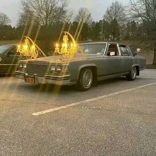 Auto s dvomi lustrami na kapote parkuje na parkovisku, svieti v podvečernom svetle.
