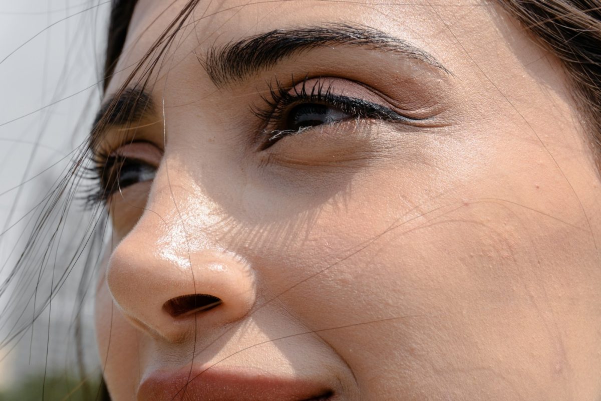 Woman's face, focused on eyes, seen in sunlight.
